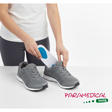 Donna che inserisce una soletta 3/4 in silicone medicale con scarichi blu in una scarpa sportiva grigia - ParamedicalShop